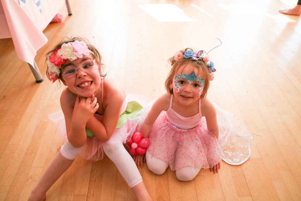 Two Flamingo Chicks in flower tutus smile at the camera