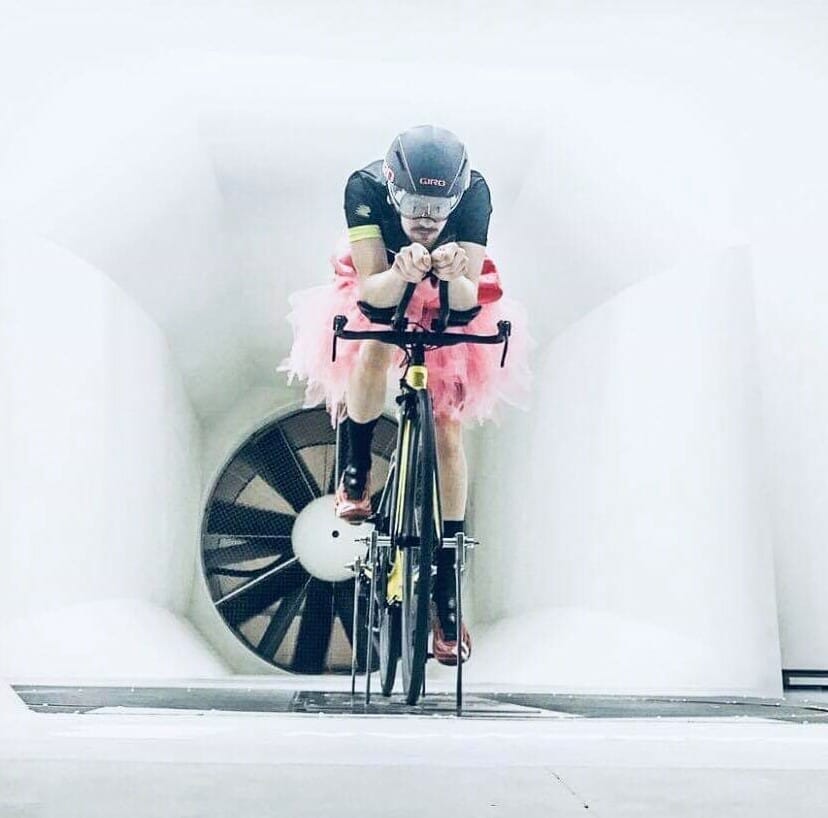 Man in tutu cycles in a wind tunnel